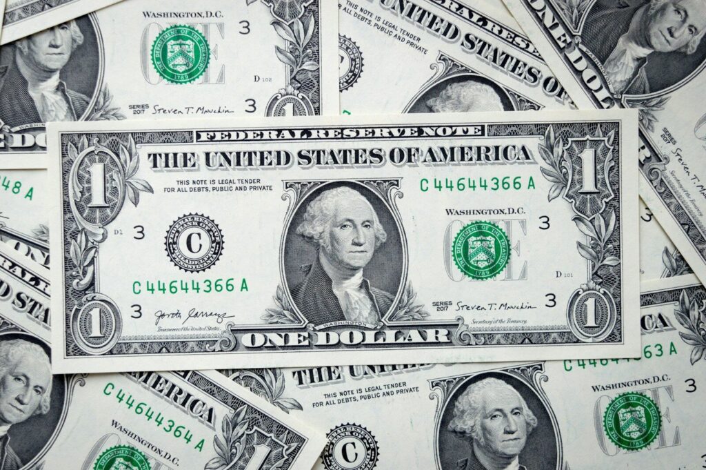 a pile of one dollar bills laying on top of each other