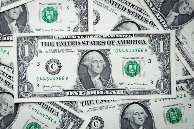 a pile of one dollar bills laying on top of each other