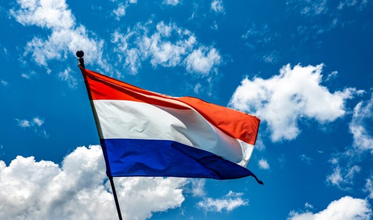 A red white and blue flag flying in the sky