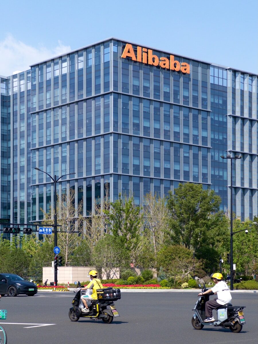 A group of people riding scooters in front of a tall building