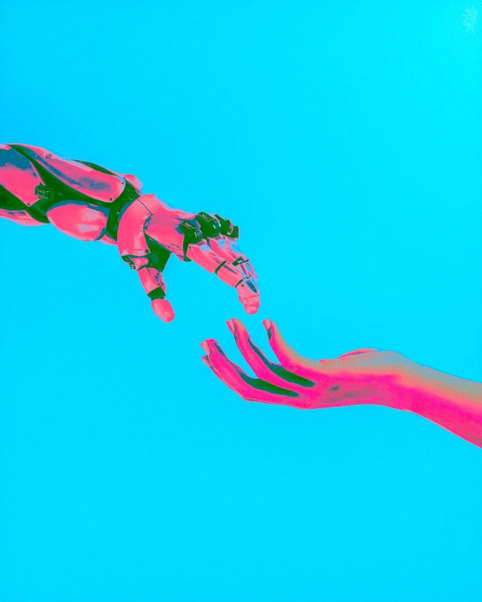 robot and human hands reaching toward each other