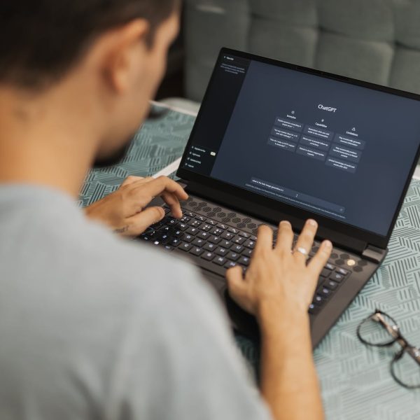 A man is typing on a laptop computer